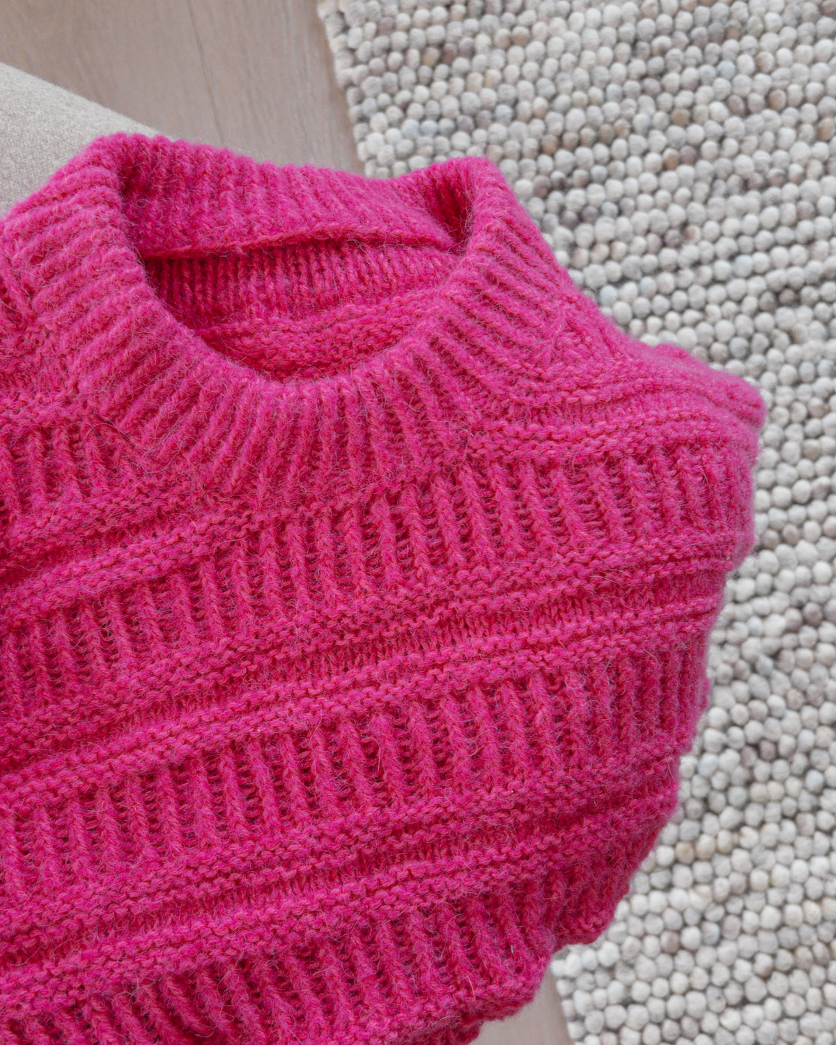 Rosa Coffee Sweater på nära håll, rund halskant i resår · halskanten stickas dubbel och fästs vid avmaskningen