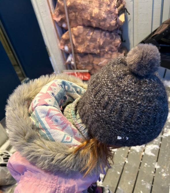 Mörk Coffee Beanie med tofs på ett barn ute i snö · åtsittande