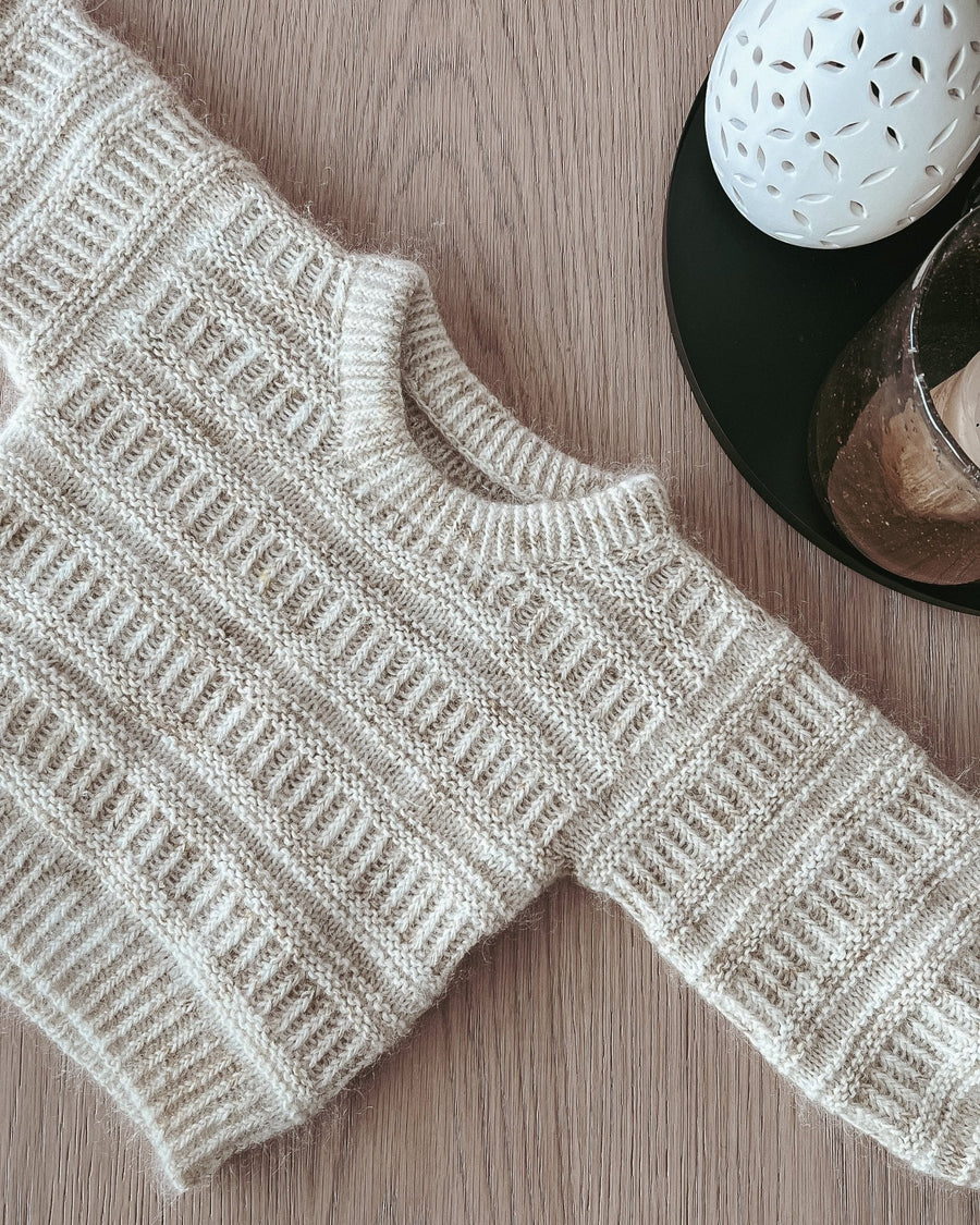 Coffee Sweater Mini liggande på ett träbord, rund halsringning · dubbel halskant
