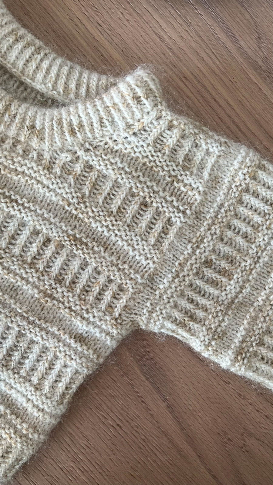 Halskant och axel på Coffee Sweater Mini, närbild · resåren kan stickas i dubbel längd